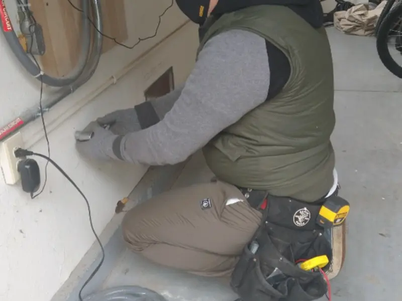 Electrician performing outlet wiring in a West Pennsboro garage